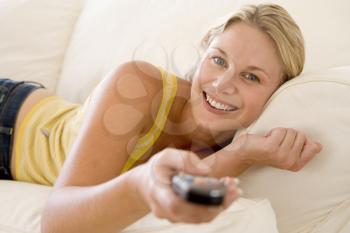Royalty Free Photo of a Woman Lying Down With a Remote