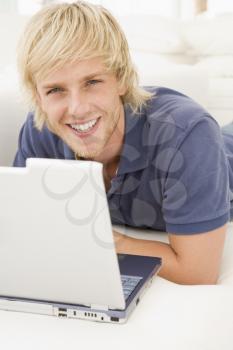 Royalty Free Photo of a Guy Lying on a Couch With a Laptop