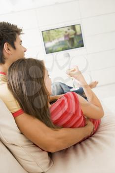 Royalty Free Photo of a Couple Watching Television Sipping Wine
