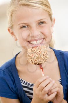 Royalty Free Photo of a Girl Eating a Candy Apple