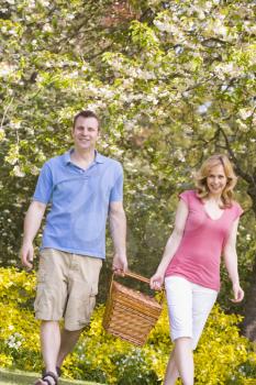 Royalty Free Photo of a Couple Walking With a Picnic Basket