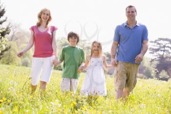 Royalty Free Photo of a Family Walking in a Field of Flowers