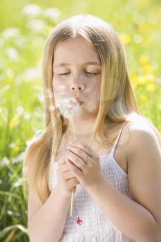 Royalty Free Photo of a Girl Blowing a Dandelion