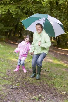 Royalty Free Photo of a Father and Daughter With an Umbrella