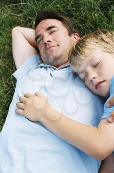 Royalty Free Photo of a Father and Son Asleep on the Grass