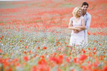 Royalty Free Photo of a Couple Hugging in a Field of Poppies