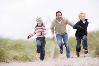 Royalty Free Photo of a Father and His Children Running in Sand Dunes