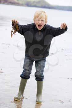 Royalty Free Photo of a Boy Standing Holding Wet Leaves