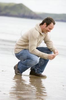 Royalty Free Photo of a Man Crouching at the Beach
