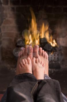 Royalty Free Photo of a Father and Son Warming Their Feet at a Fire