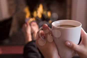 Royalty Free Photo of a Hands With a Cup By a Fire