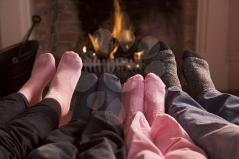 Royalty Free Photo of a Family's Feet Warming by the Fire