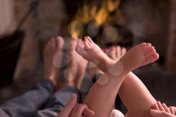 Royalty Free Photo of a Family Warming Their Feet at a Fire