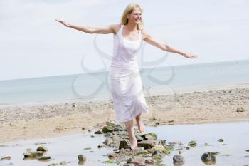 Royalty Free Photo of a Woman Walking on Rocks at the Beach