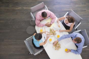 Royalty Free Photo of People in a Boardroom With Sandwiches