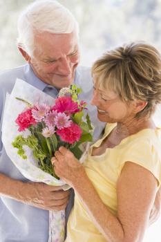 Royalty Free Photo of a Husband Giving His Wife Flowers