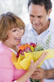 Royalty Free Photo of a Husband Giving His Wife Flowers