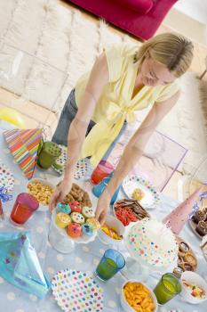 Royalty Free Photo of a Woman Setting a Birthday Party Table