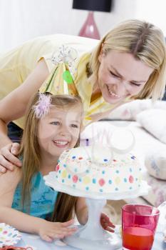 Royalty Free Photo of a Little Girl and Her Mom With Birthday Cake