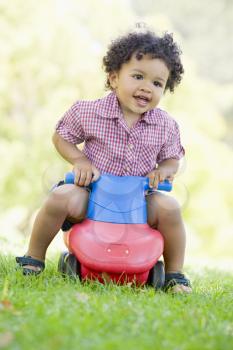 Royalty Free Clipart Image of a Little Boy on a Push Toy