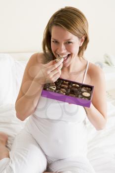 Royalty Free Photo of a Pregnant Woman Eating Chocolate