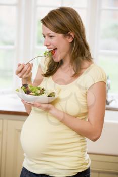 Royalty Free Photo of a Pregnant Woman Eating a Salad