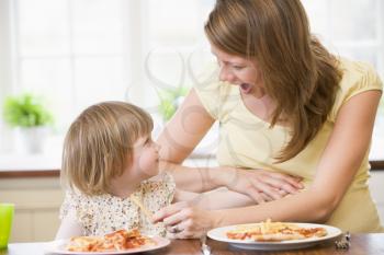 Royalty Free Photo of a Pregnant Mom Eating With Her Little Girl