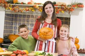 Royalty Free Photo of a Mother and Children Carving Pumpkins