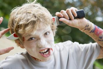 Royalty Free Photo of a Young Boy With a Halloween Gag Knife in His Head