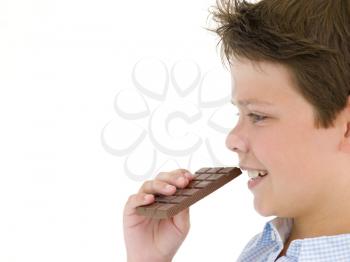 Royalty Free Photo of a Boy Eating a Chocolate Bar