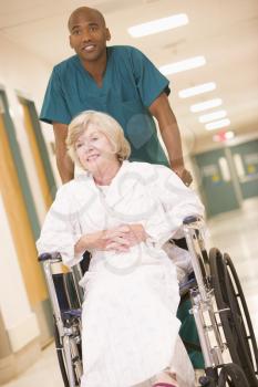 Royalty Free Photo of an Orderly Pushing a Woman in a Wheelchair