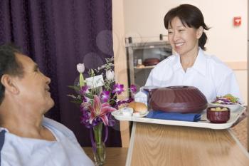 Royalty Free Photo of a Nurse Serving a Patient His Meal