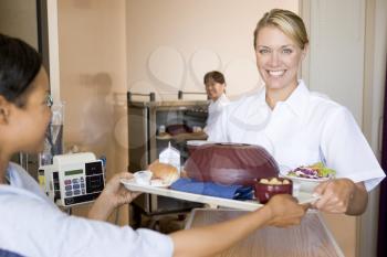 Royalty Free Photo of a Nursing Serving a Meal to a Patient