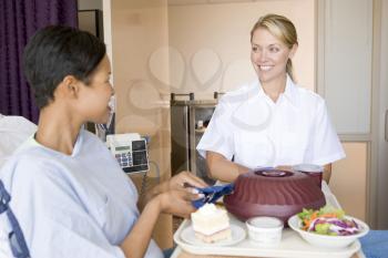 Royalty Free Photo of a Nurse Serving a Meal to a Patient
