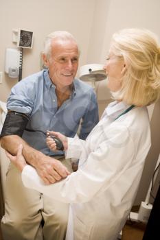 Royalty Free Photo of a Doctor Checking a Patient's Blood Pressure