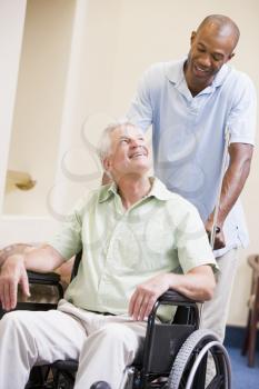 Royalty Free Photo of a Man Pushing a Man in a Wheelchair