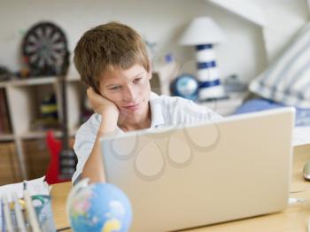 Royalty Free Photo of a Boy With His Laptop in His Bedroom