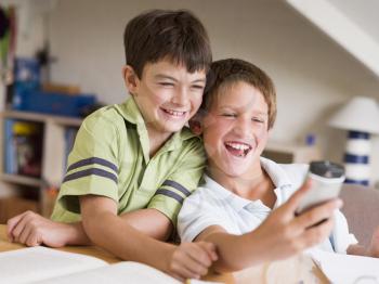 Royalty Free Photo of Two Boys Playing With a Cellphone