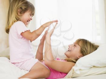 Royalty Free Photo of a Little Girl Waking Up Her Big Sister