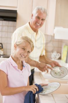 Royalty Free Photo of a Grandfather and Granddaughter Doing Dishes