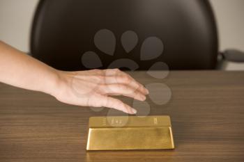 Royalty Free Photo of a Gold Bar on a Desk