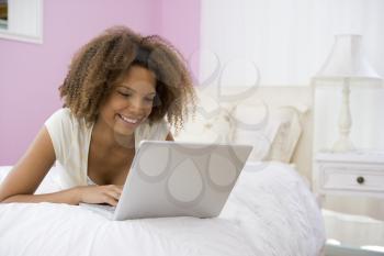 Royalty Free Photo of a Girl on the Bed With a Laptop