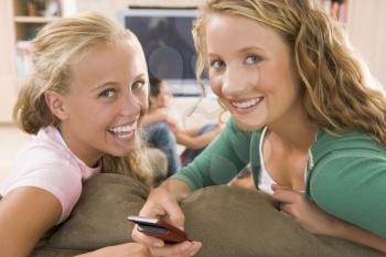 Royalty Free Photo of Teens in Front of a TV Using a Cellphone