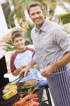 Royalty Free Photo of a Father and Son Barbecuing