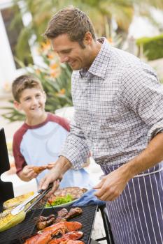 Royalty Free Photo of a Father and Son Barbecuing