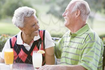Royalty Free Photo of a Couple Enjoying a Drink at a Golf Course