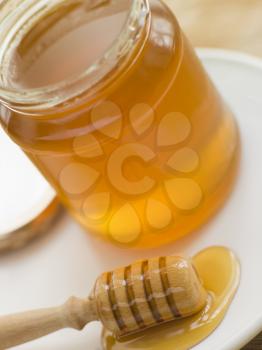 Royalty Free Photo of a Jar of Honey and a Spoon