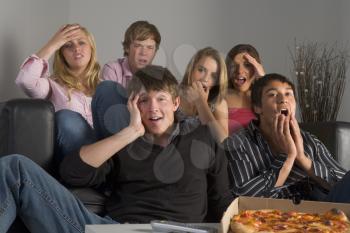 Royalty Free Photo of Teens Looking Upset and Eating Pizza