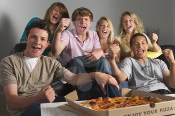Royalty Free Photo of Teens Eating Pizza and Cheering
