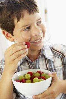 Royalty Free Photo of a Young Boy Eating Fruit